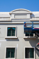 Shot of a maintenance workers working at heights, repairing facade of the building. Industrial