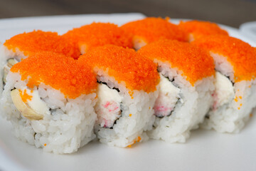 Salmon and caviar rolls set sushi on white plate