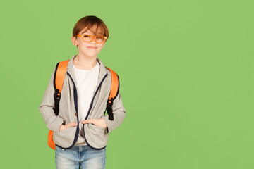 Handsome boy with backpack ready to study. Back to school concept. Cute school kid in glasses over...