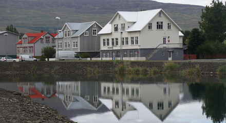 traditional houses reflecting in the sea water, Akureyri, Iceland