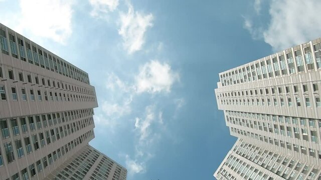 Footage 4k Timelapse, looking up at similar residential buildings in South Korea with moving clouds. Clear sunny day. Homes with smart home function.