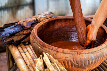 Dyeing fabrics with bark and volcanic mud. Traditional Isan Thai silk weaving. Silk Akkanee in...