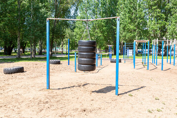 Fototapeta na wymiar Car tires for sports training are suspended on chains