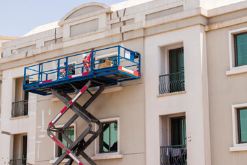 Shot of a maintenance workers working at heights, repairing facade of the building. Industrial