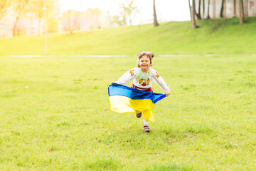 Girl with the flag of Ukraine. She is dressed in an embroidered shirt and a wreath on her head - Ukrainian national dress. August 24 - Independence Day of Ukraine.
