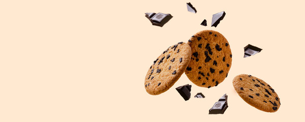 Tasty fresh biscuits and pieces of dark chocolate against bright yellow background.Empty space