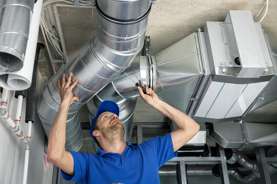 hvac services - worker install ducted pipe system for ventilation and air conditioning in house