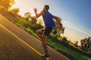 Silhouette of Young man running sprinting on road. Fit runner fitness runner during outdoor workout...