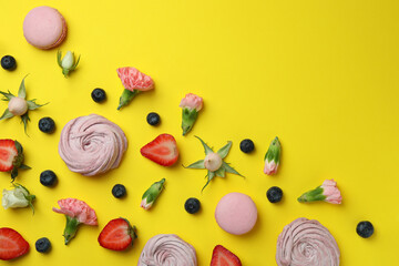 Concept of tasty macaroons and marshmallows on yellow background