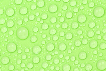 Water drops on green background texture. Backdrop glass covered with drops of water. green bubbles...