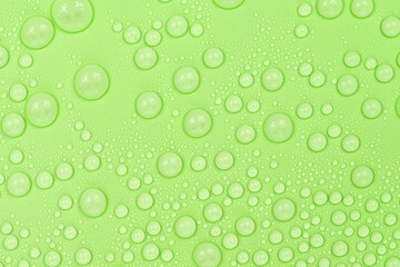 Water drops on green background texture. Backdrop glass covered with drops of water. green bubbles...