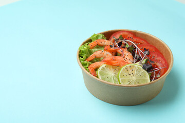 Concept of tasty eating with shrimp salad on blue background