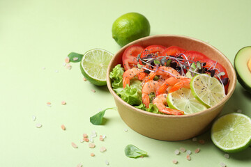 Tasty shrimp salad on green background, space for text