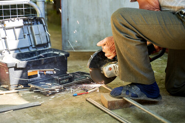 a man cuts a titanium tube with a grinder