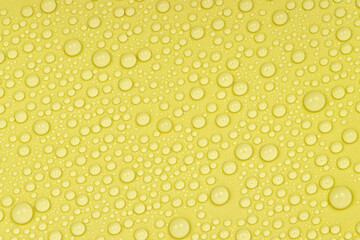 Water drops on yellow background texture. Backdrop glass covered with drops of water. yellow bubbles in water. beer texture