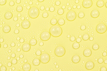 Water drops on yellow background texture. Backdrop glass covered with drops of water. yellow...