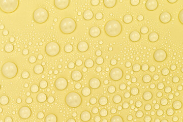 Water drops on yellow background texture. Backdrop glass covered with drops of water. yellow bubbles in water. beer texture