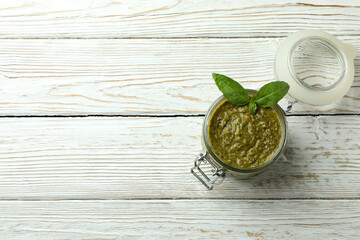 Obraz na płótnie Canvas Jar of Pesto sauce on white wooden background