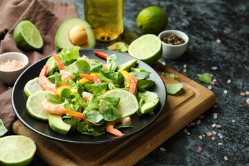 Concept of tasty eating with shrimp salad on black smokey background