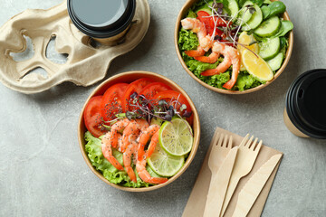 Concept of tasty eating with shrimp salads on gray table