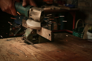 Handyman is cutting metal with grinder