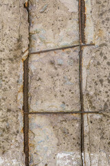 Damaged reinforced concrete with exposed rusty steel construction grid