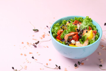 Concept of tasty eating with shrimp salad on pink background