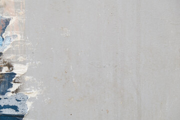 Detail of torn poster on a gray metal surface with a lot of copy space.