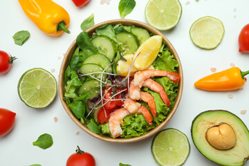 Tasty shrimp salad and ingredients on white background