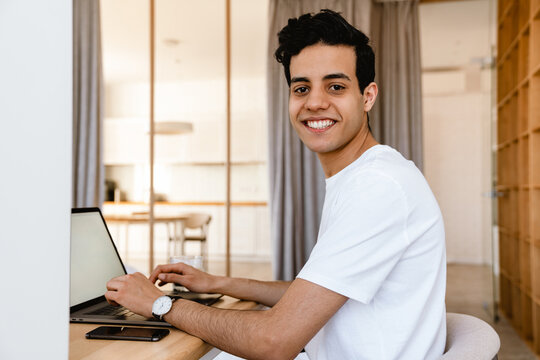 Smiling Young Hispanic Man Working Studying On Laptop