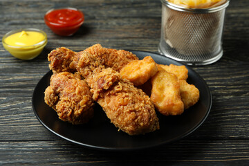 Concept of tasty eating with fried chicken on wooden background