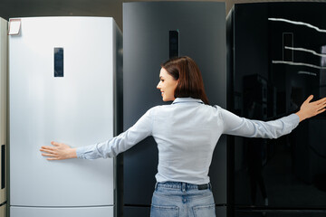 Fototapeta na wymiar Young happy woman leaning on her new refrigerator in a mall