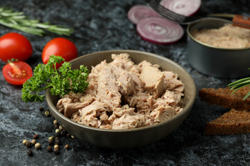 Concept of tasty eating with canned tuna on black smokey background
