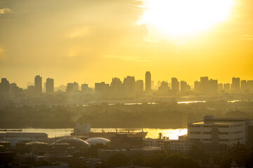 Obraz premium The blurred abstract background of the morning sun exposure to the tiny dust particles that surround the tall buildings in the capital, the long-term health issue of pollution.