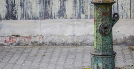 Fototapeta na wymiar Old out of order street water pump