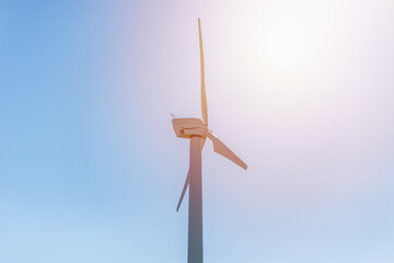 One wind power turbine and sun,blue sky.wind power concept with copy space. Technology in nature...