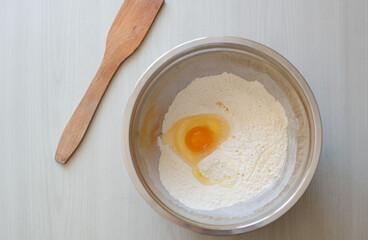 Cooking pastries, take eggs, flour, containers and a wooden spatula