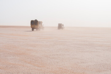 Off-road vehicle in a sandstorm / Off-road vehicle drive in the sandstorm, Sahara, on the Lac...