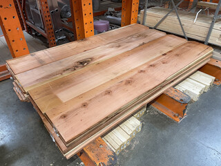 Stacks of new redwood picket fence boards on patio