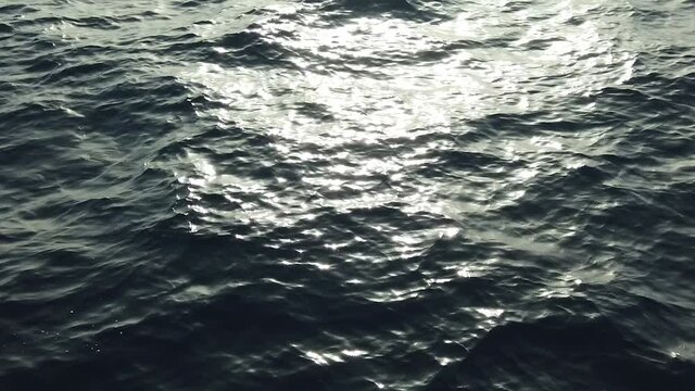 Vue de dessus sur la mer bleue p&eacute;trole en slow motion avec la r&eacute;flexion du soleil