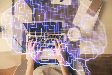 Double exposure of woman working on computer andhuman brain hologram drawing. Top View. Ai concept.
