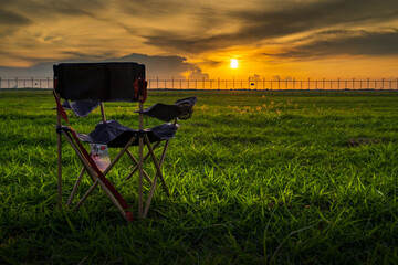 Empty chair in meadow. Field with dry grass. Summer or autumn season. Camping and adventure time concept. Copy space