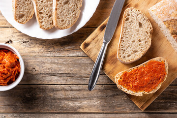 Sliced toast bread with sobrasada on rustic wooden table. Typical Mallorca food in Spain.	