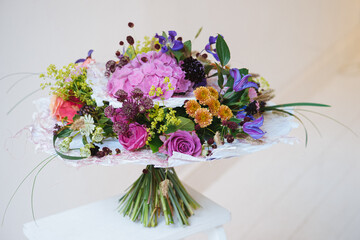 Colorful wedding bouquet on a white table on a white wall background