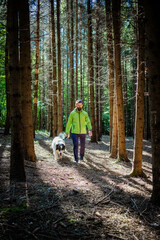 man with dog walking in forest