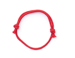 Red thread, string as amulet for wrist isolated on white. Red bracelet with knots. Top view. - obrazy, fototapety, plakaty