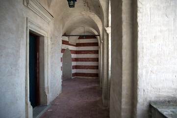 Fototapeta na wymiar Architektura stare korytarze za sklepieniami i kamienną posadzką