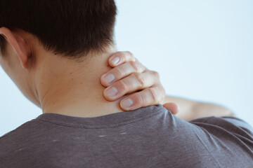 Fototapeta premium People, healthcare and problem concept - close up of man suffering from neck pain over gray background