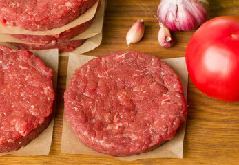 various raw burger ingredients on wooden desk