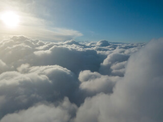 Fototapeta premium Aerial high flight above the clouds at sunrise.